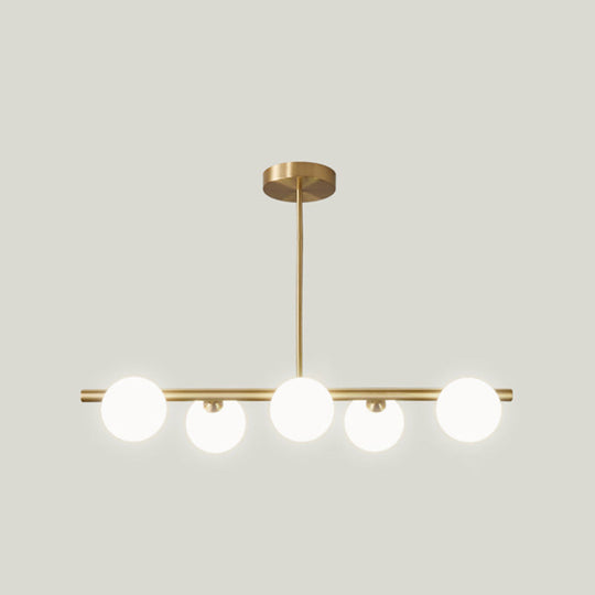 Sleek And Elegant Linear Gold Island Pendant Lighting With Spherical Glass Shades For Dining Table