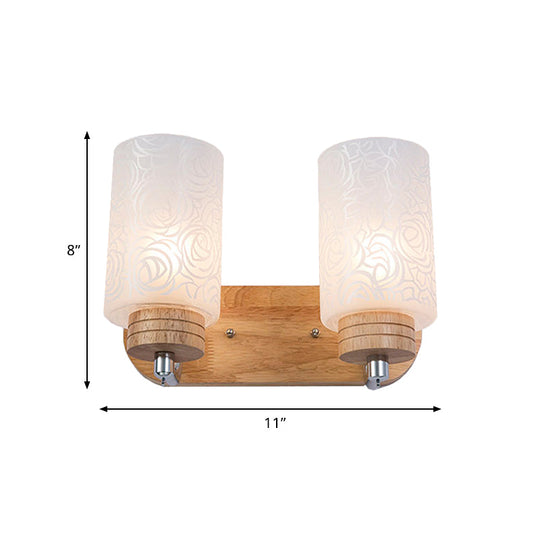 Modern 2-Headed White Glass Cylinder Wall Sconce With Wood Mount And Rose Pattern