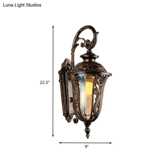 Bronze Metal Outdoor Wall Sconce With Curved Arm Amber Glass Shade - 1-Light Lamp