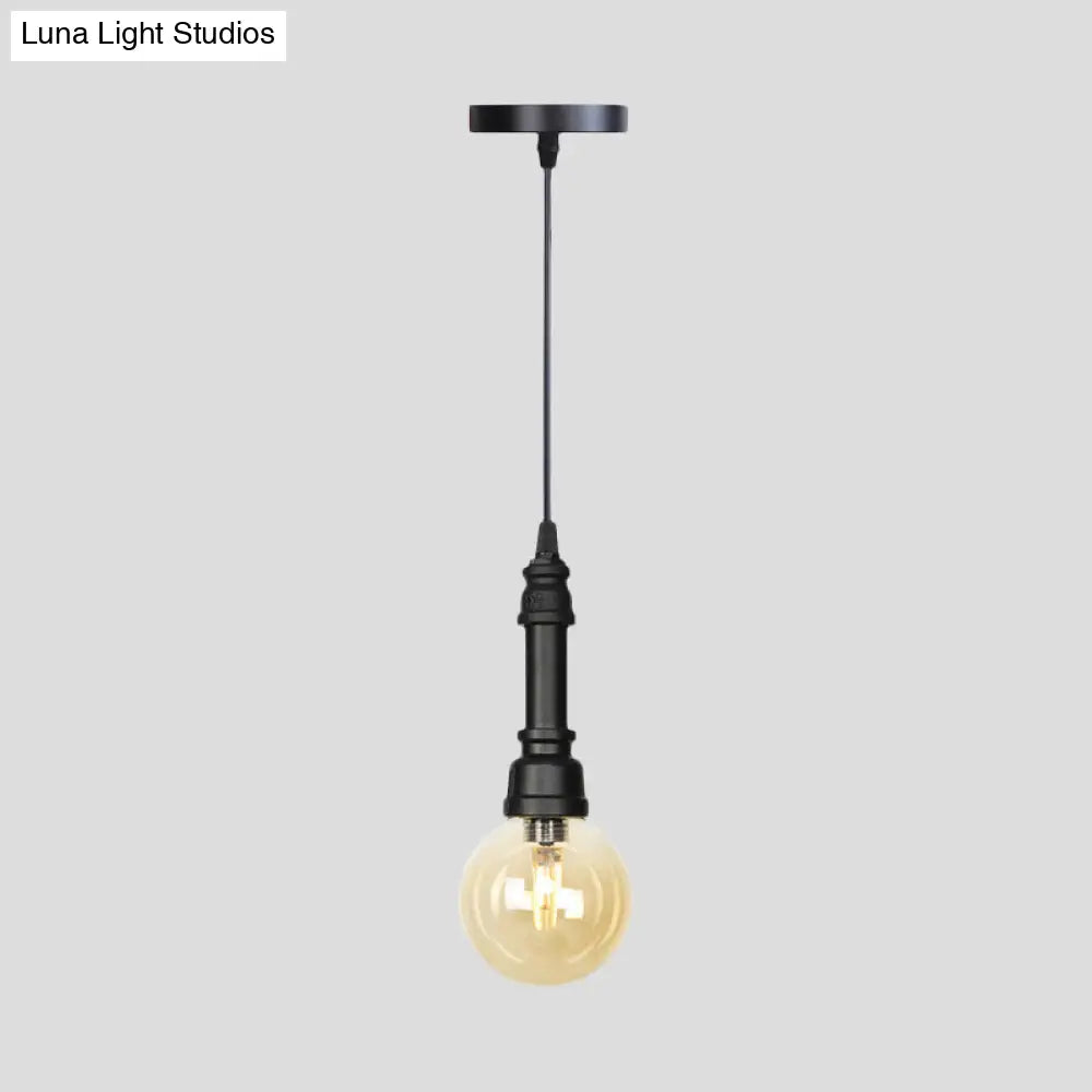 Industrial Black Finish Amber Glass Pendant Lamp With Pipe Suspension - 1-Light Ball/Capsule