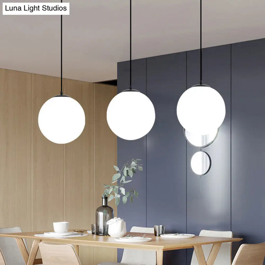 Sleek Black Sphere Restaurant Pendant Light With Cream Glass Shade - Simple Ceiling Hang Lamp